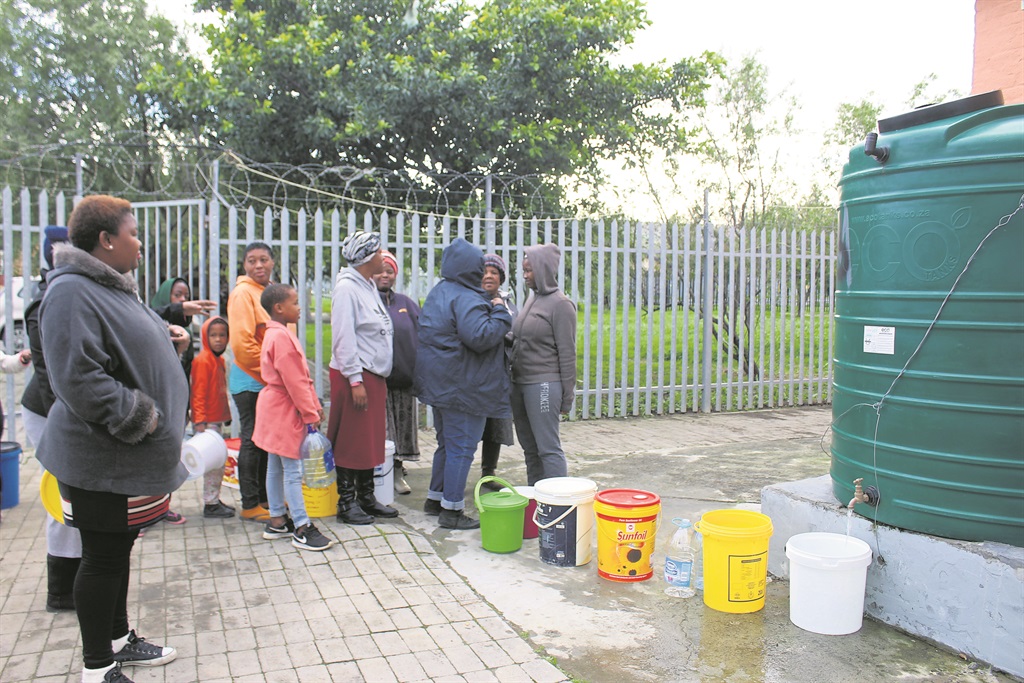 Residents wait for their turn to get water from a JoJo tank in Strand. Photo by Velani Ludidi