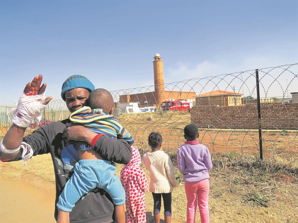 Thapelo Mosa (right) led these children out of a burning building. Photo by Sammy Moretsi