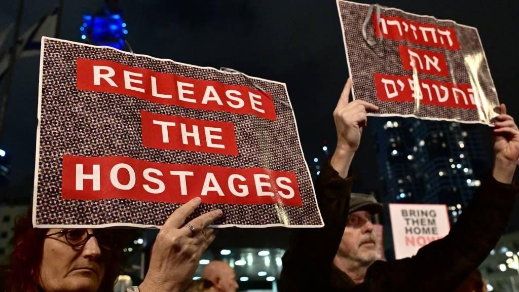 Protesters lift placards during a rally for suppor