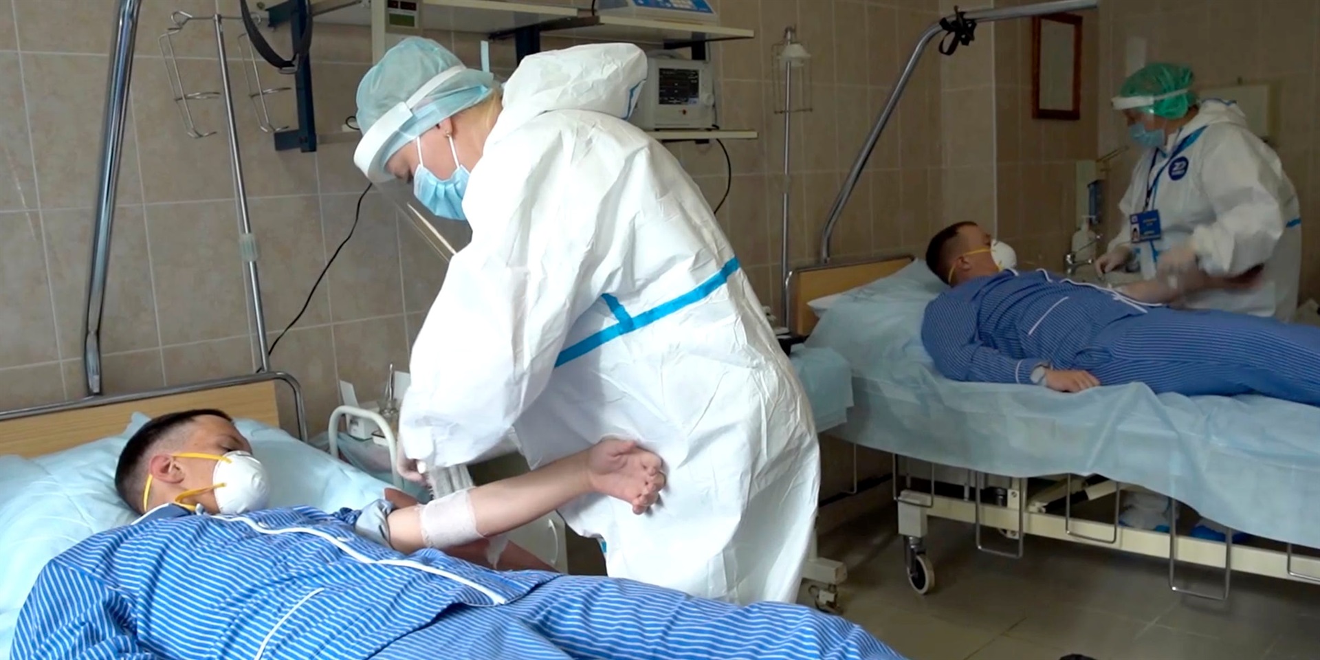 Medical workers in protective gear prepare to draw blood from volunteers participating in a trial of a coronavirus vaccine at the Budenko Main Military Hospital outside Moscow, Russia, on July 15, 2020. 