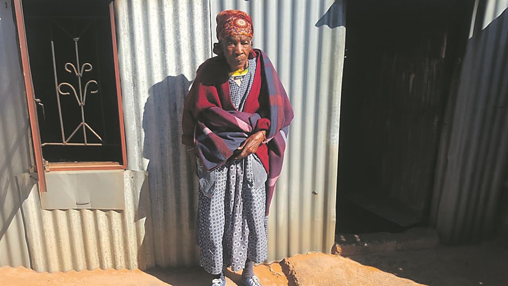 Gogo Lena Seemule outside her shack. Inset: The wood that gogo has to store in her house.