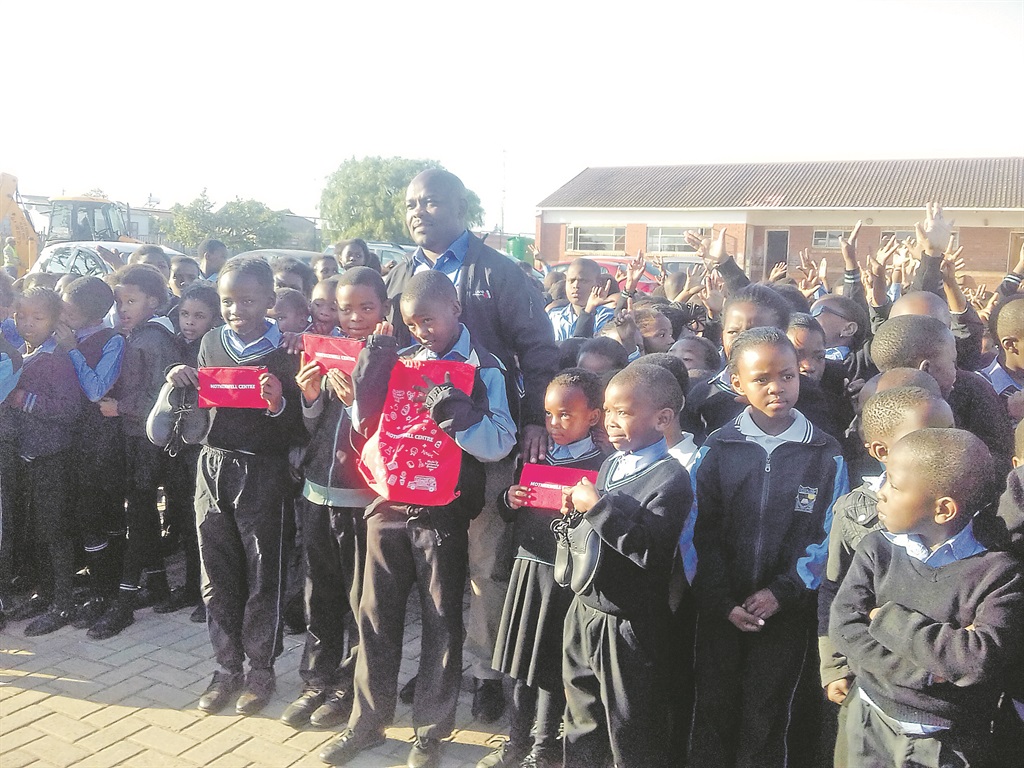 Motherwell Shopping Centre manager Mzo Limba was surrounded by Empumalanga Primary School pupils when new school shoes were handed over on Thursday. Photo by Joseph Chirume 
