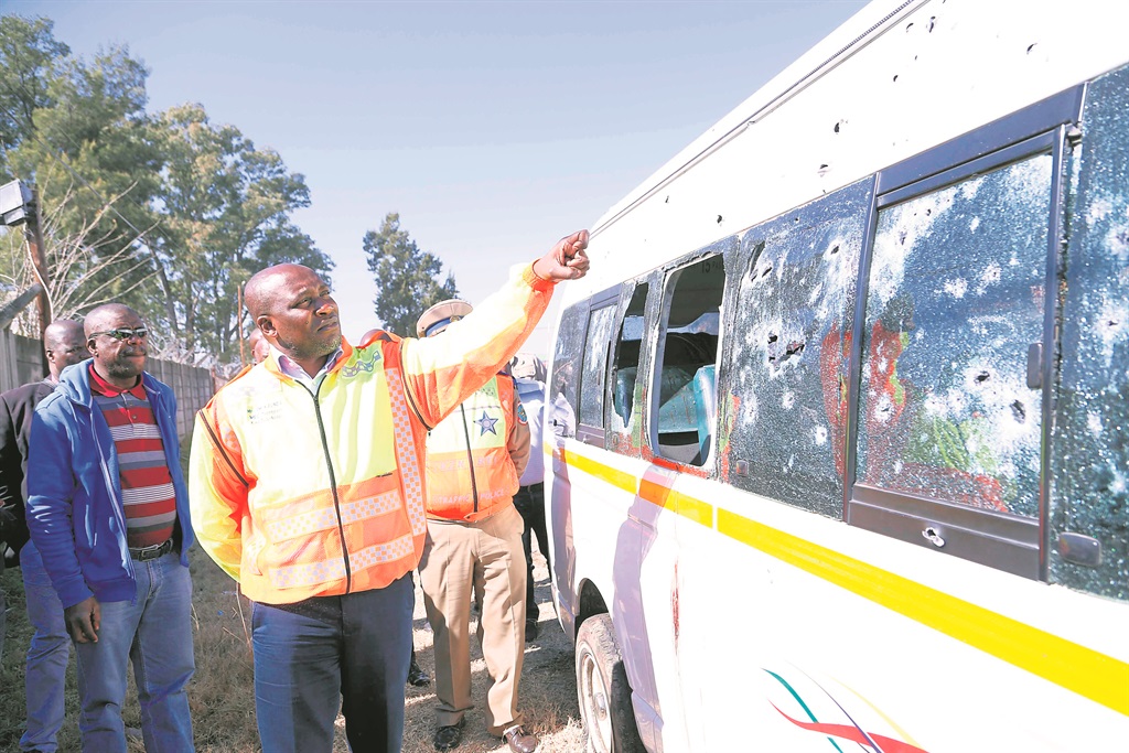 KZN Transport MEC Mxolisi Kaunda examines the vehicle ambushed in a suspected incident of taxi violence at the weekend. 