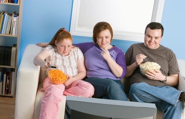 overweight parents and child watching tv 