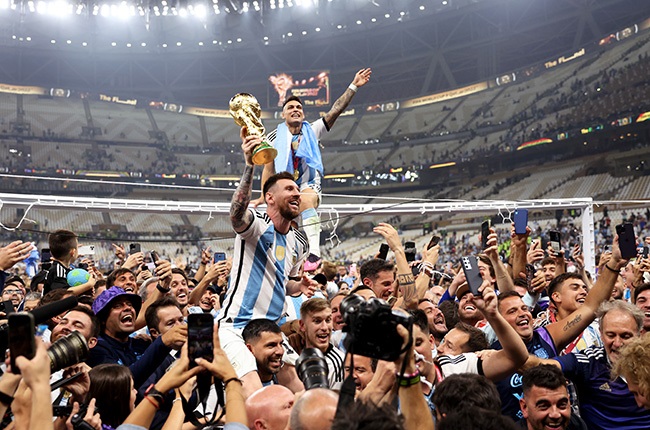 Lionel Messi of Argentina celebrates with teammates and the FIFA World Cup Qatar 2022 Winners Trophy. (Photo by Clive Brunskill/Getty Images)
