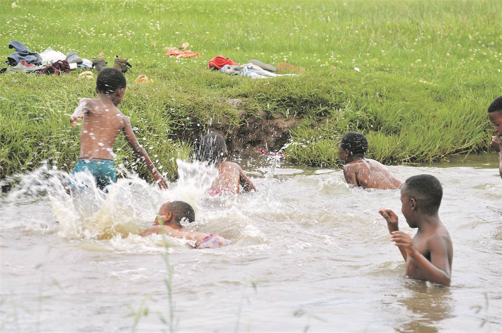 When the heatwave hits, boys from Orange Farm swim in a local stream. However, they swim in kak water as sewage from broken manholes spill into the stream.             Photos by Tumelo Mofokeng