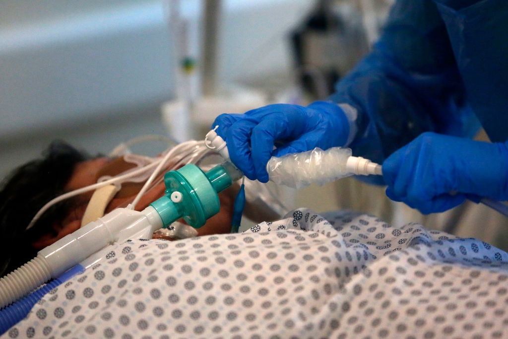 A nurse checks a Covid-19 patient's ventilator.