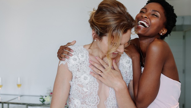 A bride and her bridesmaid share a funny moment