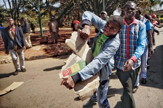 Supporters of the opposition party Movement for Democratic
Change (MDC), tear up ballot booths as they demand results of general election in
Harare, Zimbabwe. (AFP)

