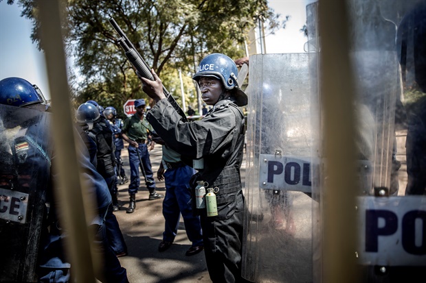 <p>Zimbabwean anti riot police officers stand guard and close
the gate of the Rainbow Towers where the election's results were announced, as
supporters of the opposition party Movement for Democratic Change (MDC) protest
against alleged widespread fraud by the election authority and ruling party, in
Harare. 
</p><p>Zimbabwe's ruling Zanu-PF party won the most
seats in parliament, official results showed on August 1, 2018, but EU
observers criticised the Zimbabwe elections for being held on an "un-level
playing field". (AFP)

</p>