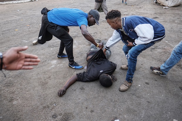 <p>A man lies on the ground after the Zimbabwean army opened fire
in central Harare as protests erupted over alleged fraud in the country's
election. </p><p>The man died after being shot in the stomach, an AFP
photographer said, confirming that he died at the scene. (<strong>AFP</strong>)

</p>