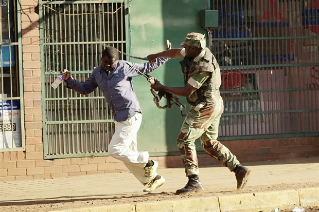 <p>A Zimbabwean soldier beats a man in a street of Harare as
protests erupts over alleged fraud in the country's election. </p><p>One man was shot
dead, AFP witnessed, after the Zimbabwean army opened fire in central Harare.</p><p>President Emmerson Mnangagwa has called for peace. - <strong>AFP
</strong></p>
