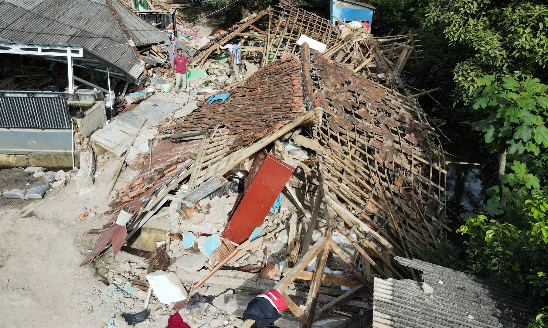 ’n Inwoner soek deur die puin van ’n huis wat ineengestort het nadat ’n aardbewing Maandag die dorp Cianjur in Indonesië getref het. Foto: Reuters