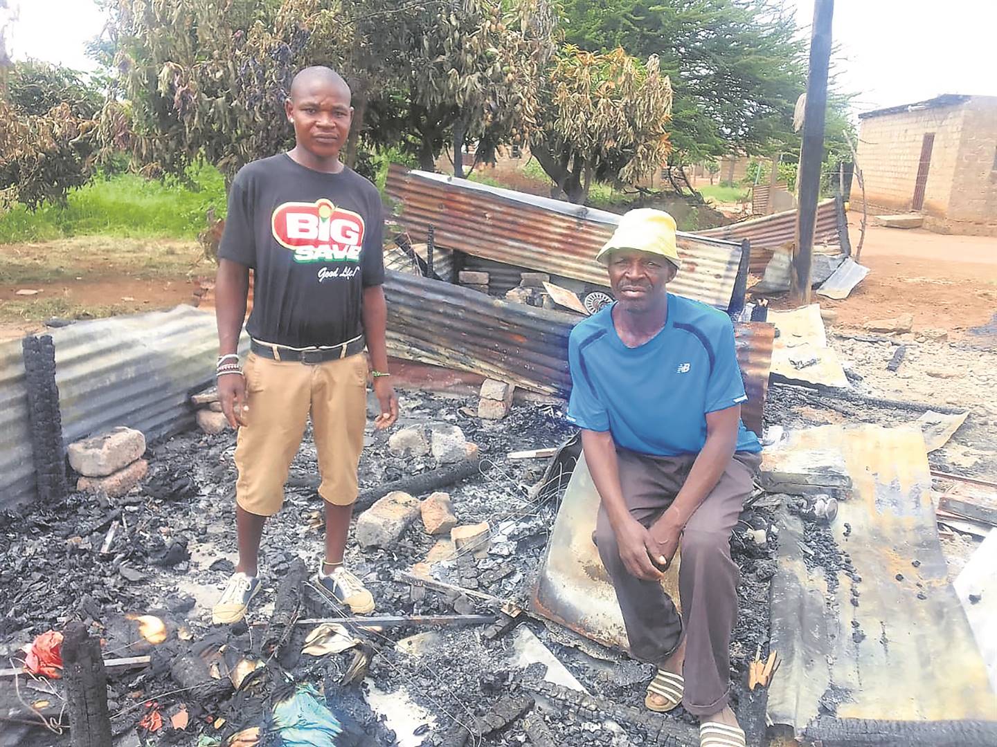 Gogo Pauline Sithole’s grandson Mpho and son Samuel are asking for help to rebuild her shack. Photo by Raymond Morare