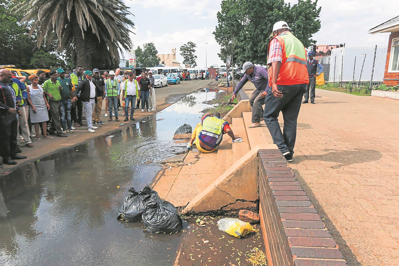 Gauteng Premier Panyaza Lesufi is helped out of a puddle of water at Vereeniging Taxi Rank.    Photo by Tumelo Mofokeng