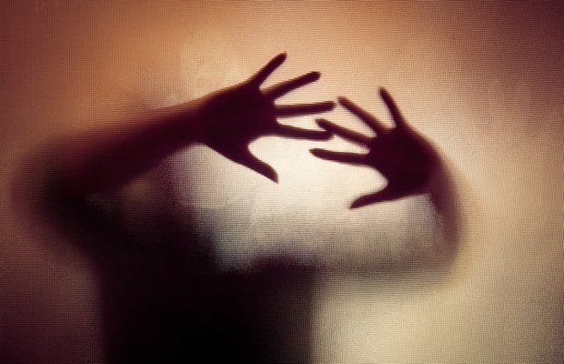 silhouette of hands pressed on glass
