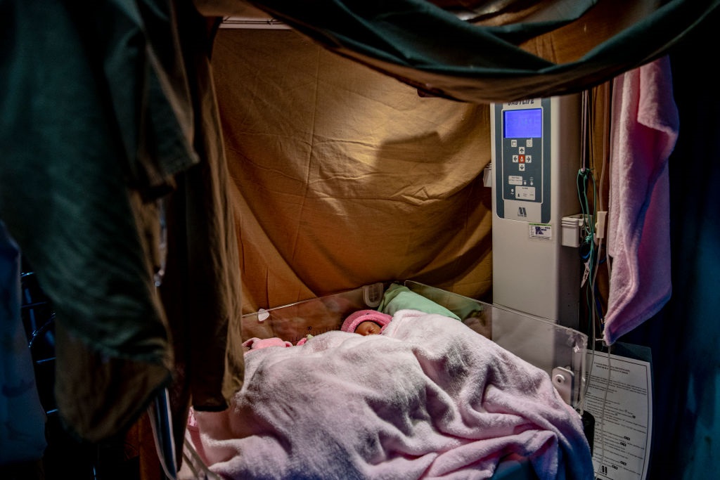 Newborn babies are treated in a makeshift infant c