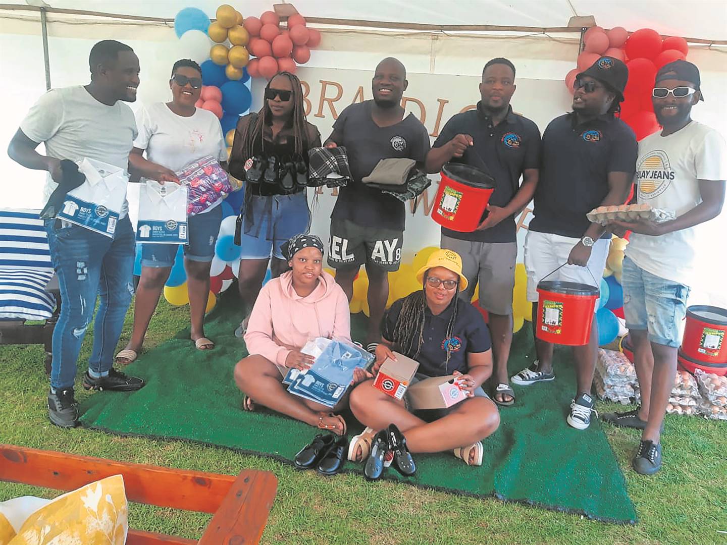 Tshepo Moloto (third from right) and residents with the food and clothes they collected for the needy. Photo by Bongani Mthimunye