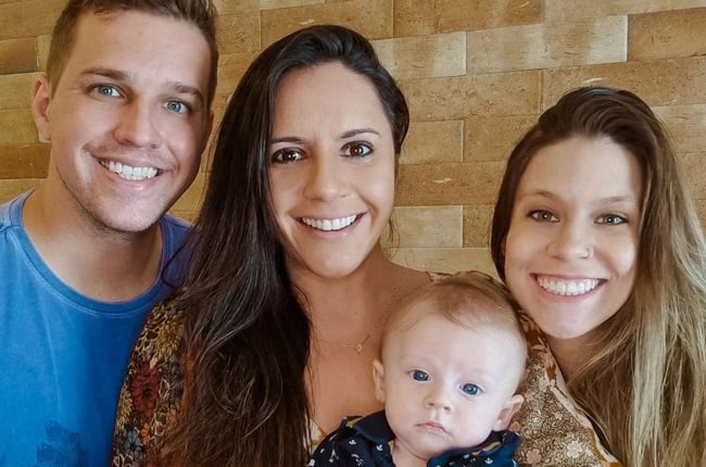 Carol Rizola, (right) Douglas Queiroz (left) and Kah Marques, (middle) and their child Henrique pose in a photo released on social media with the announcement of a second pregnancy.