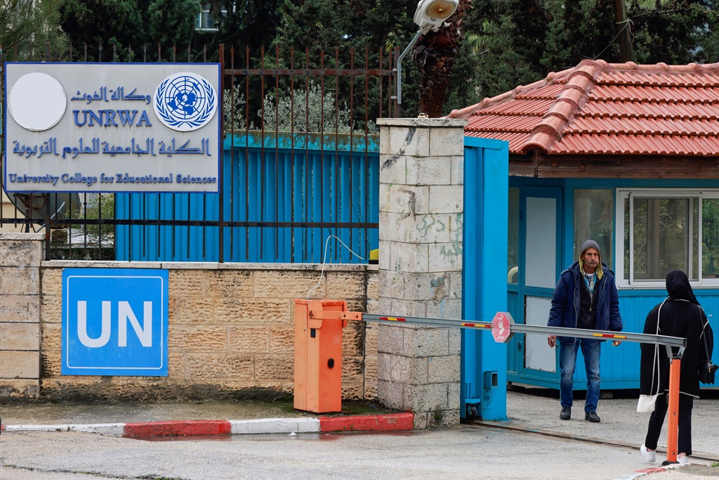 Palestinians stand at the entrance of the UNRWA-run University College for Educational Science Ramallah city in the occupied West Bank on 29 January 2024. UN Secretary-General Antonio Guterres pleaded for continued support for UNRWA, the United Nations agency for Palestinian refugees, which is threatened by a fierce row over alleged staff involvement in Hamas's 7 October attack that started the war.