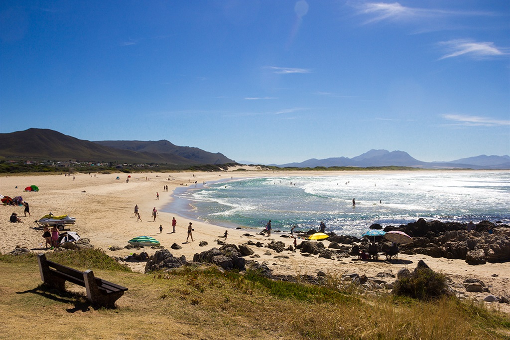 Holidaymakers and swimmers enjoy the endless white sands of the beach and gentle waves of the Atlantic Ocean at the resort town of Kleinmond in the Western Cape Province of South Africa. Photo: Galloimages/Gettyimages.com