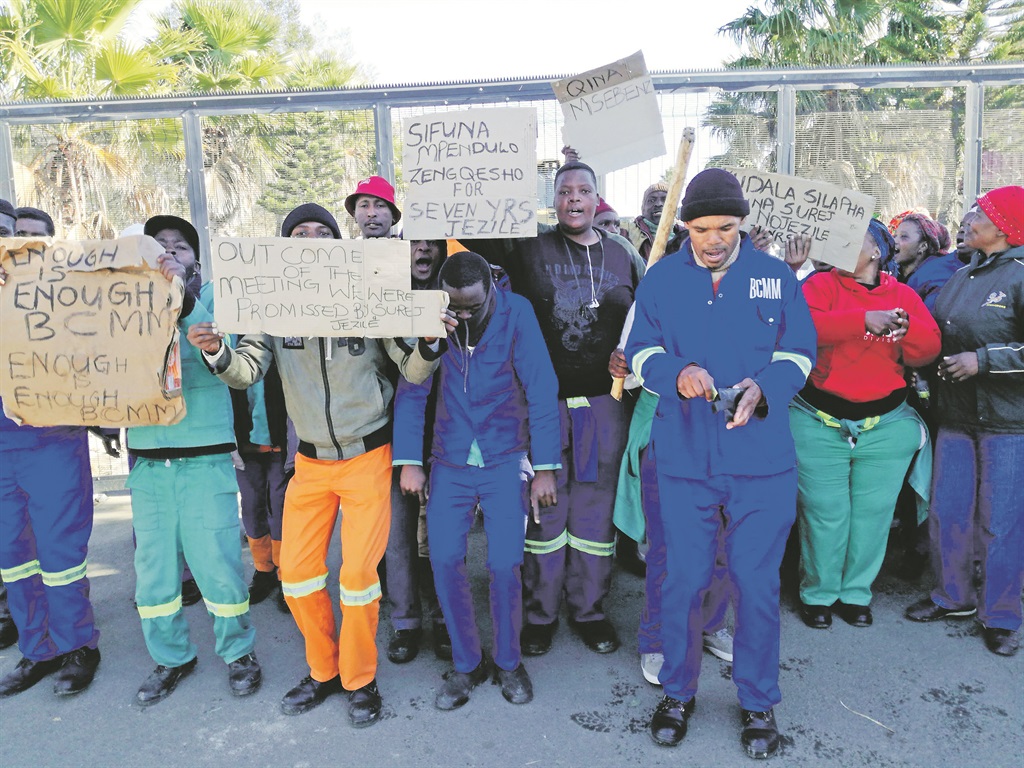 These casual workers closed the gates of Fort Jackson Cemetery, near Mdantsane, on Saturday. Photo by Lizwe Dangala