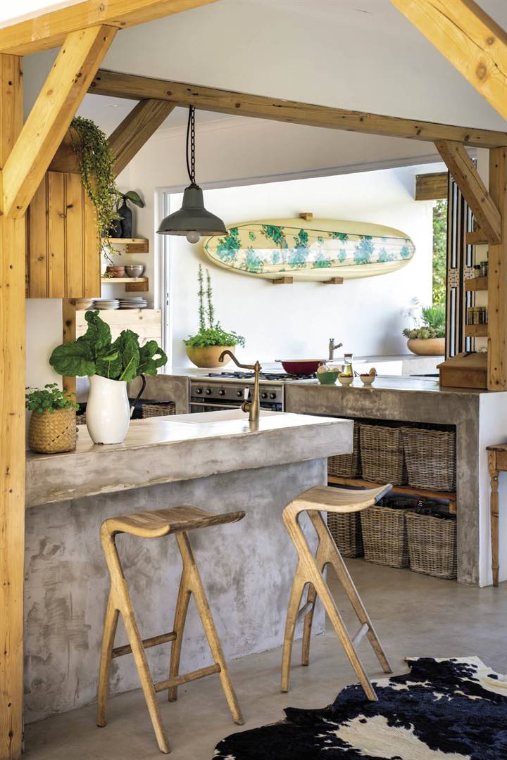 The kitchen used to be a bedroom with no sea-facing windows. Thanks to stacking windows that open onto the veranda, outdoor entertaining is now a breeze. While cooking up a storm, Marc – a keen home cook who lost the argument about the stove’s position – can admire a surfboard that holds fond memories of trips to Jeffreys Bay and teaching his daughter Tayla (now 29) 
to surf.  
Bar stools from Cielo; 
copper tap from TIC Bathrooms; lab sink 
from House Shop