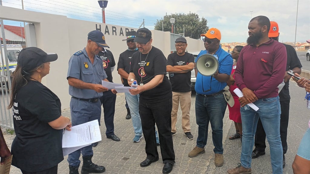 Khayelitsha Eastern Sub-Structure director James Kruger handing over a memorandum to Harare police station commander Col Junaid Alcok outside the station.