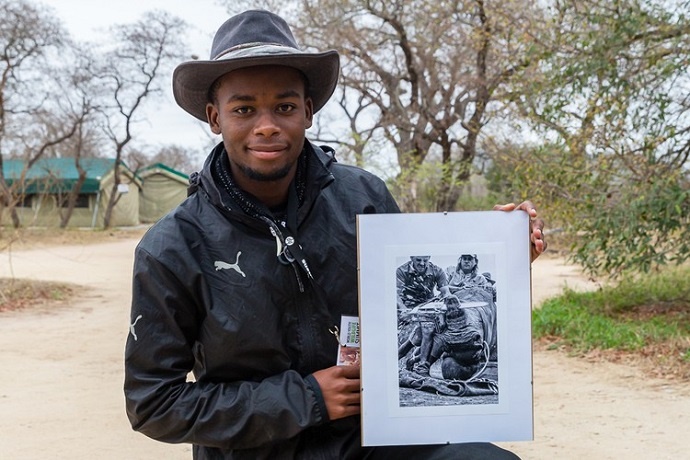 Kgaugelo Neville Ngomane from Bushbuckridge holds the photo that won the Young Environmental Photographer of the Year Award. Photo courtesy of Wild Shot Outreach