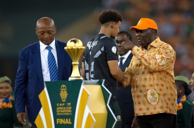 Bafana Bafana captain Ronwen Williams, left, greets the president of Ivory Coast, Alassane Ouattara, right, after receiving the Golden Glove award during the prize giving ceremony after the Africa Cup of Nations final. The South Africans had beaten DR Congo in the third-place play-off match. (Photo by MB Media/Getty Images)