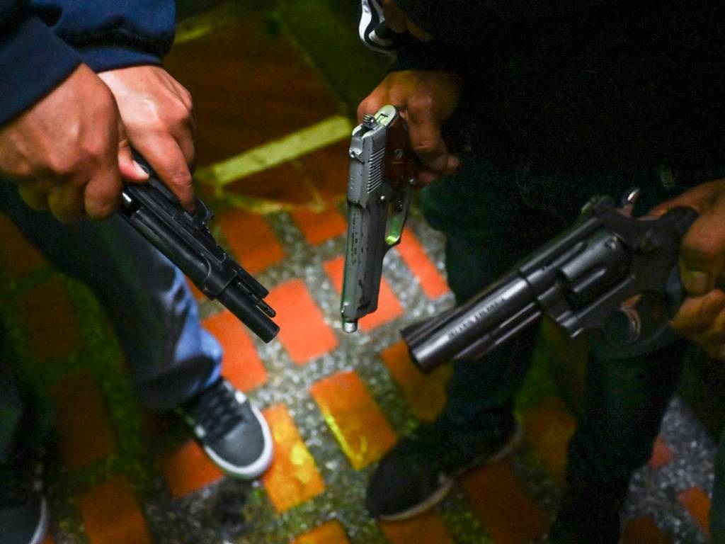 Members of the Oficina de Envigado criminal organisation show their guns at a house in Medellin, Colombia. 