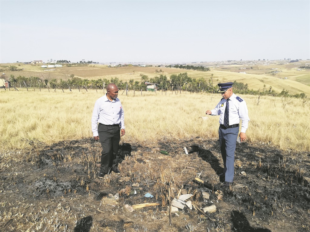 gruesome Nkosi Mwelo Nonkonyana looks on as Lieutenant Colonel Arnold Freemantle points out where Nkosi Thulani Mjanyelwa was burnt to death               PHOTO: Lubabalo Ngcukana