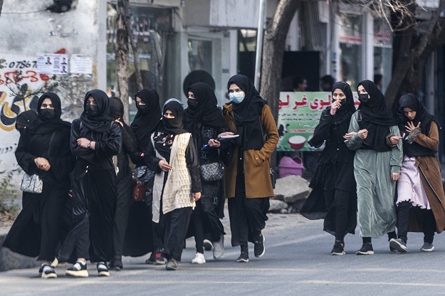 Afghan high school girls return from school after taking part in their high school graduation exam in Kabul on Wednesday. 
