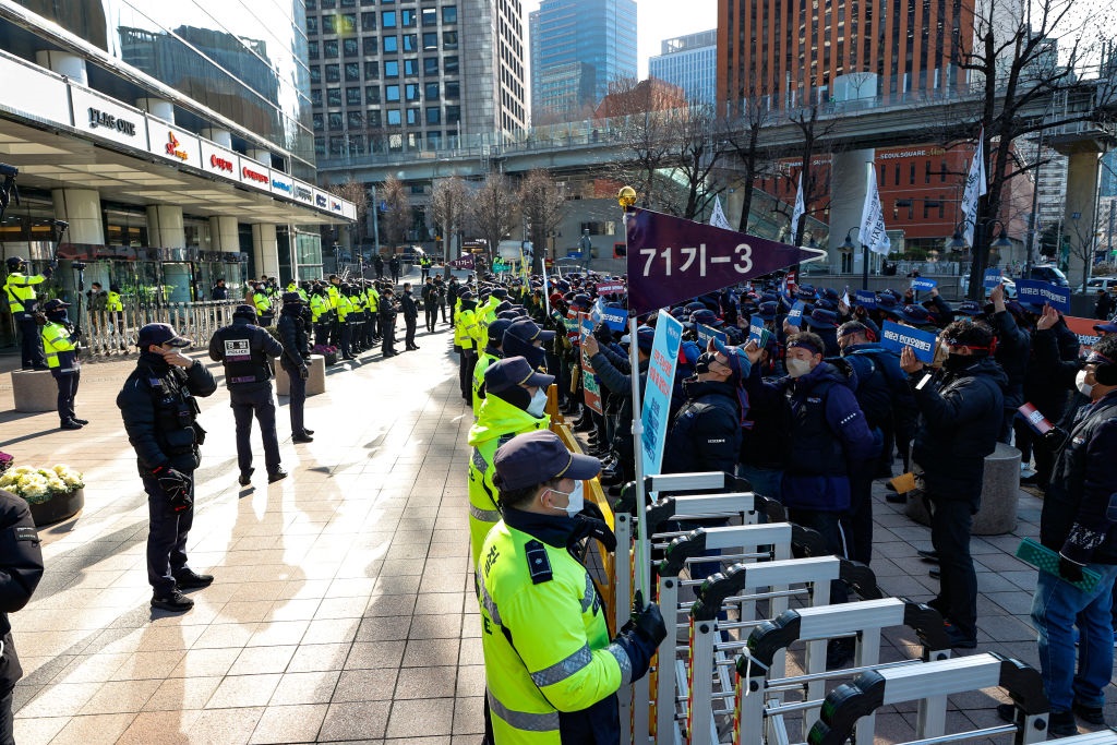 About a hundred members of the Korean Public Service and Transport workers Union Incheon Headquarters shout slogans at the cargo workers all-out resolution protest in front of the Hyundai Oilbank Seoul office on December 7, 2022.