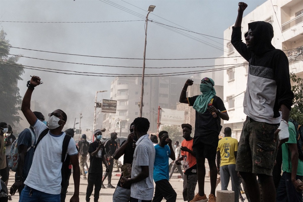 Protesters shout slogans during clashes with police on the sidelines of a protest against a last-minute delay of presidential elections in Dakar on 9 February 2024.