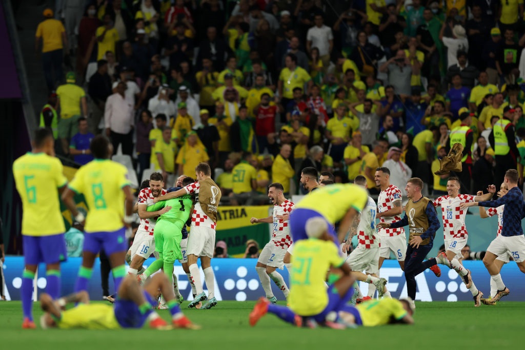 Dominik Livakovic of Croatia celebrates after Marquinhos of Brazil (not pictured) hits the post and misses the deciding penalty in the penalty shootout during the FIFA World Cup quarter-final match between Croatia and Brazil (Photo by Lars Baron/Getty Images)