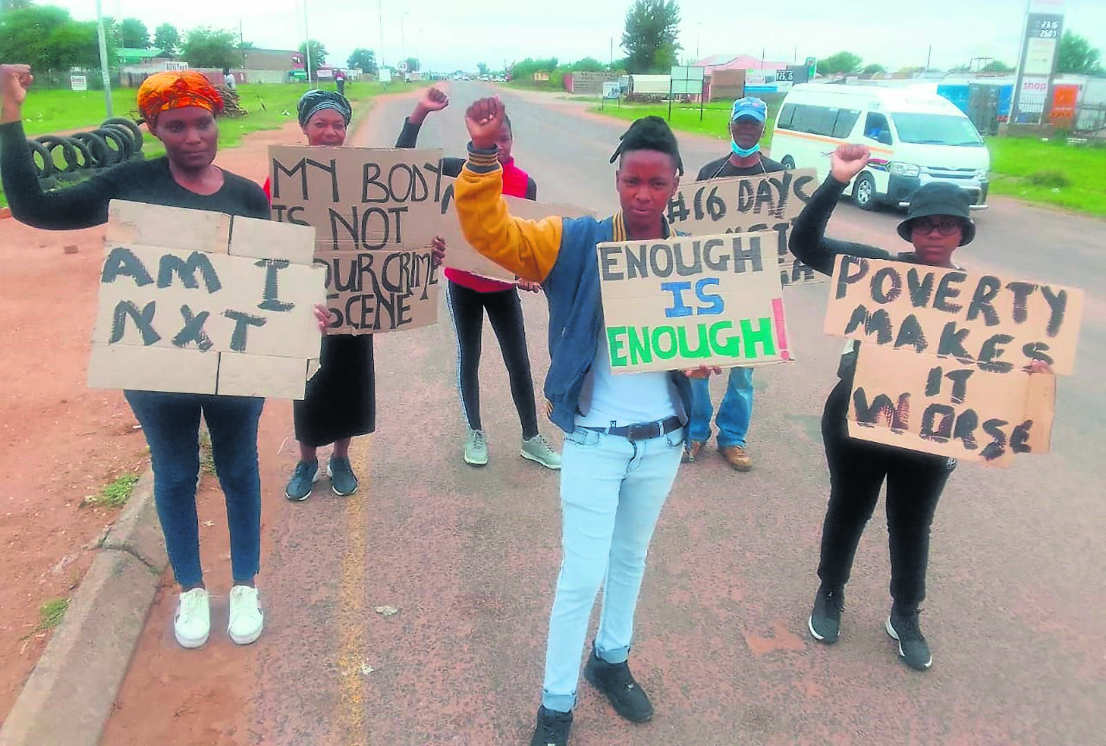 Demonstrators holding up placards as they walk along Molefe Makinta Road in Stinkwater in protest against gender-based violence.       Photo by Raymond Morare