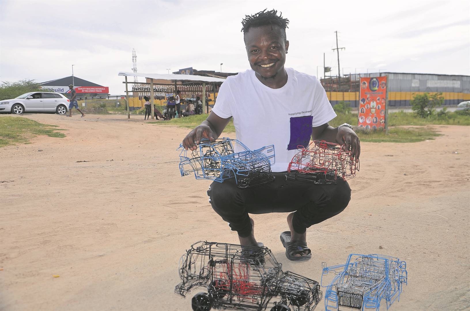 Dan Mgiba showcases the wire cars he designs and makes.                Photo by Oris Mnisi