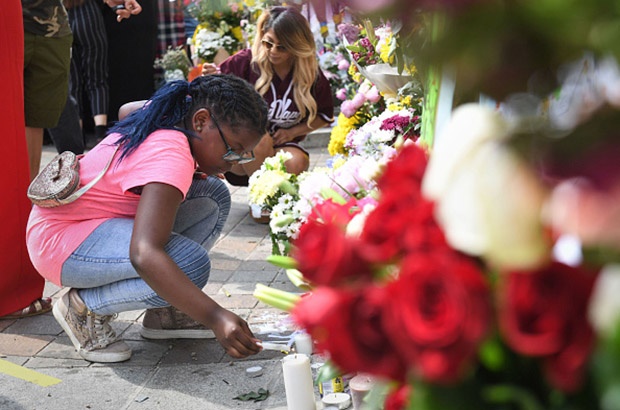 Avigail Cunningham (9) lights a candle next to tributes at Notting Hill Methodist Church near Grenfell Tower in west London after a fire engulfed the 24-storey building.
