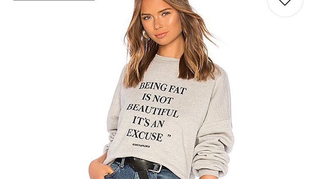 Model wearing sweatshirt that says "Being fat is not beautiful, it's an excuse"