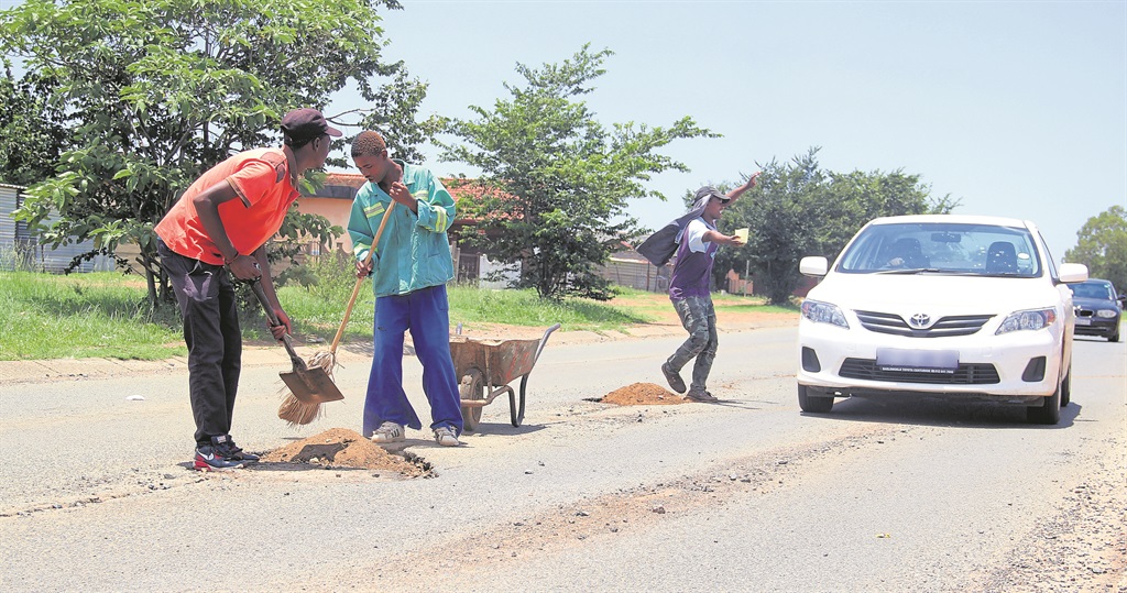 From left: Siyabonga Maseko, Sipho Monyake and Mojalefa Theletsane close potholes in their kasi and get tips from residents.    Photo by Collen Mashababa