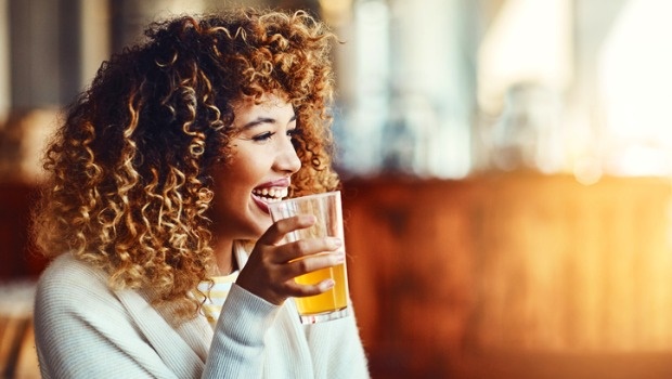 A woman enjoys a glass of beer