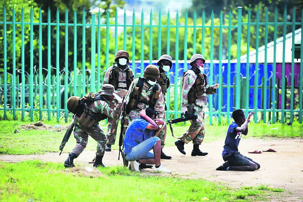 Members of the army force two men to the ground in Alexandra township to punish them for breaking the country’s lockdown rules. The SA National Defence Force has been accused of being heavy-handed Picture: Trevor Kunene
