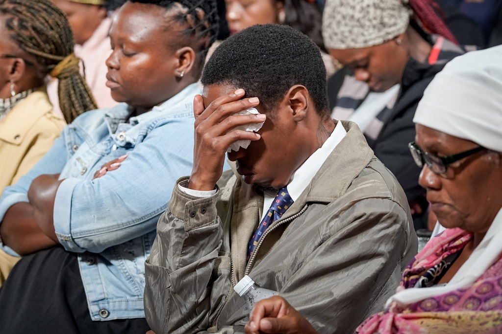 A mourner holds their head in their hands during speeches at a service for the victims of the Boksburg tanker explosion at the Boksburg Civic Centre, 30 December 2022. A service was held for the victims of the explosion which left 34 dead a day before Christmas. (Photo: Yeshiel Panchia/News24)