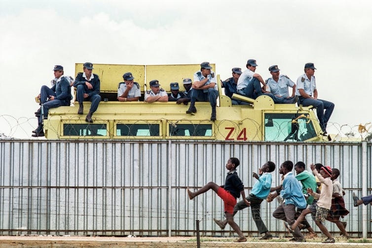 Graeme Williams’s photograph he took in Thokoza township, near Johannesburg, in 1991. Police watch an ANC rally.(Graeme Williams)