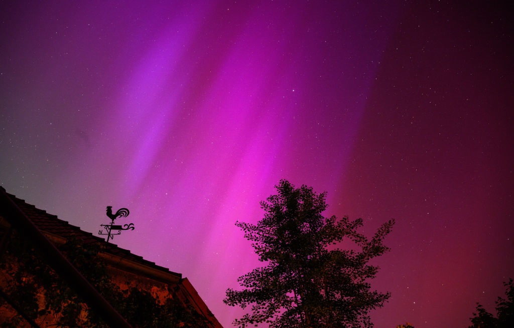 Northern lights can be seen behind a weathercock a