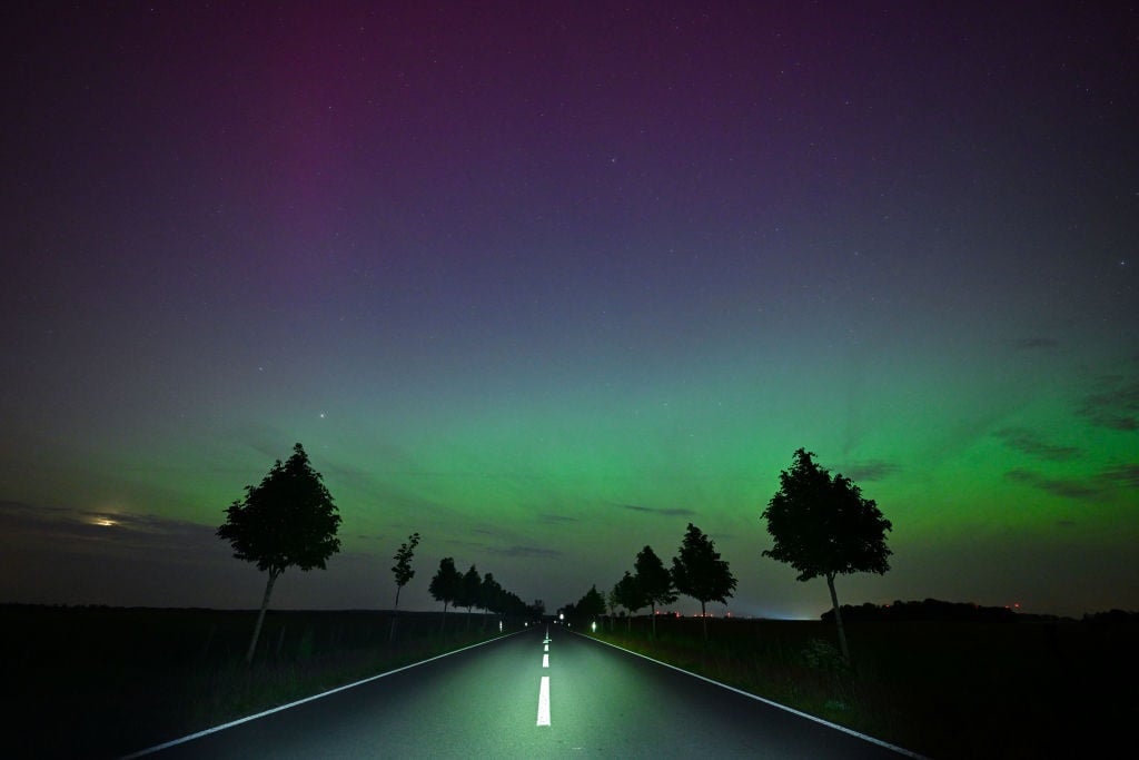 Light green and slightly reddish auroras glow in t