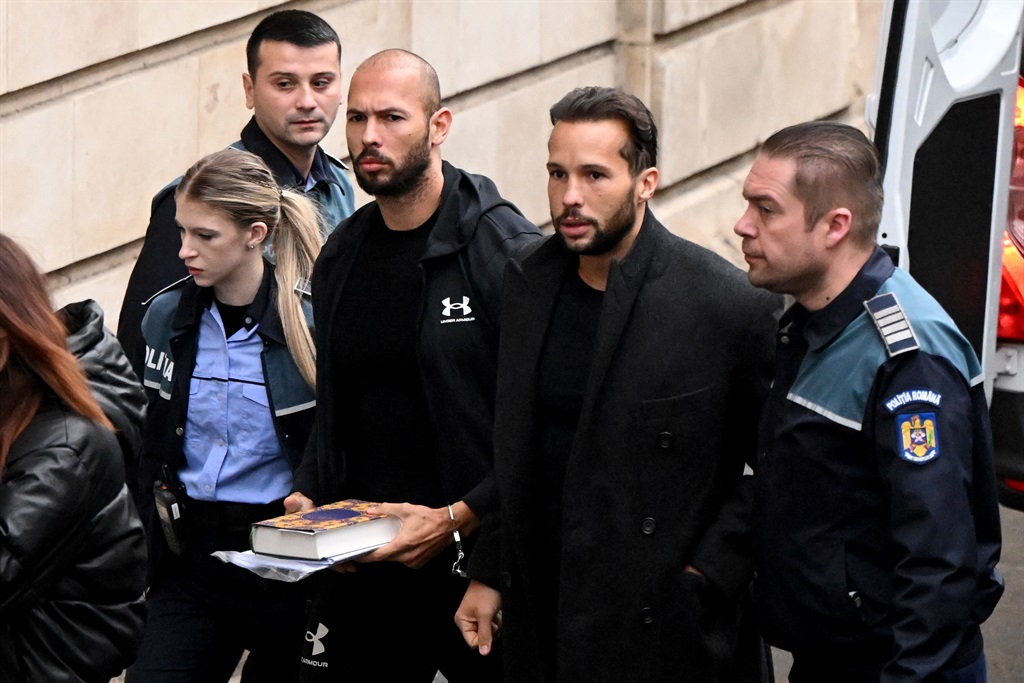 British-US former professional kickboxer and controversial influencer Andrew Tate (3rd R) and his brother Tristan Tate (2nd R) arrive handcuffed and escorted by police at a courthouse in Bucharest.
