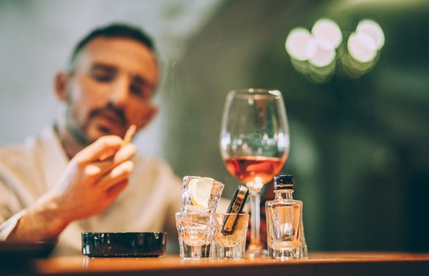 man drinking wine while smoking 