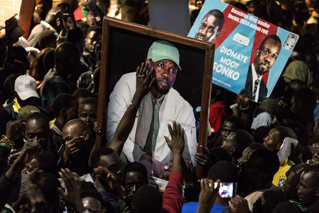 Supporters of Senegalese opposition leader Ousmane Sonko and presidential candidate Bassirou Diomaye Faye celebrate after the two men were released from prison, in Dakar on 14 March 2024. (John Wessels/ AFP)